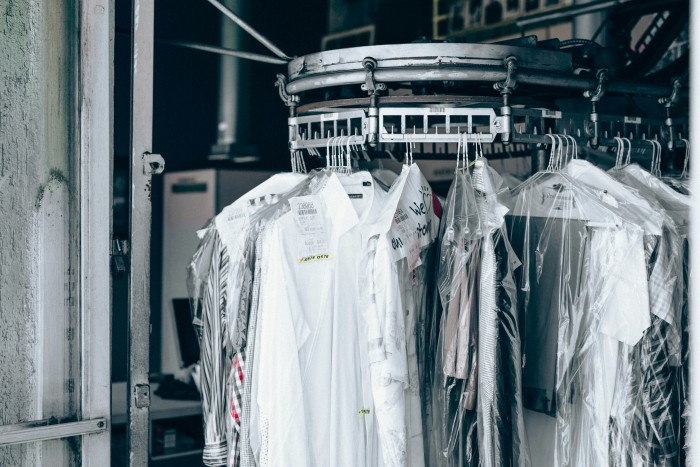 Professional dry cleaning service with freshly cleaned garments hanging on a rack